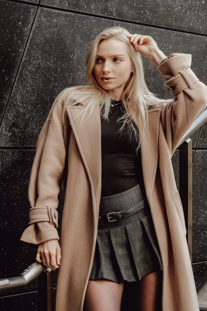 Home Stylish woman posing in a wool coat and mini skirt, showcasing winter fashion elegance.